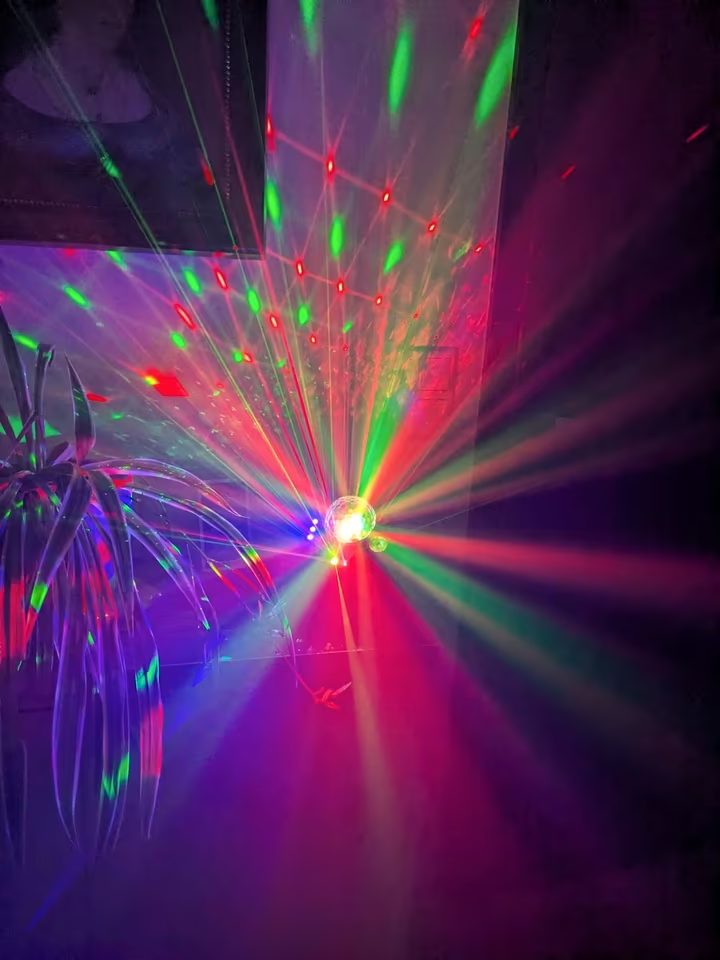 LED-Discokugel wirft bunte Lichtpunkte und Strahlen durch den ganzen Raum