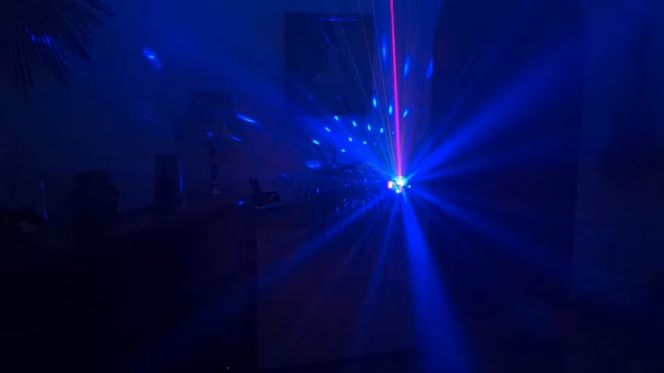 Blaue Lichteffekte mit Laserlinie und leichtem Nebel im Partyraum